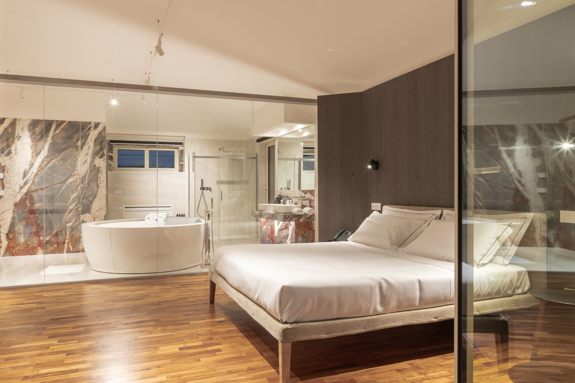 Suite Prestige con letto in primo piano e vasca idromassaggio sullo sfondo